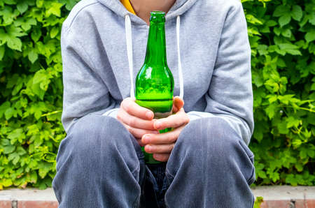 Young Person hold a Beer Bottle outdoor closeupの写真素材