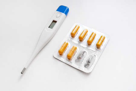 Thermometer with a Pills on the White Background closeup