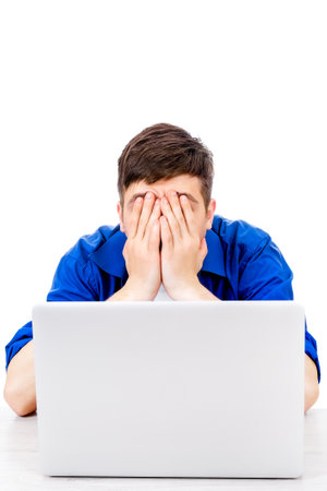 Sad Young Man with Laptop cover his Face with a Hands Isolated on the White Backgroundの写真素材