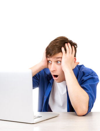 Shocked Young Man with Laptop Isolated on the White Backgroundの写真素材