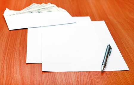 Blank Paper on the Table closeup and American Dollars in Backgroundの写真素材