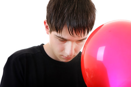 Sad Young Man with a Balloon Isolated on the White Backgroundの写真素材