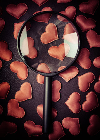 Magnifying Glass on the Scattered Red Hearts closeupの写真素材