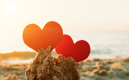 Two Red Hearts in the Sand at the Evening Beachの写真素材