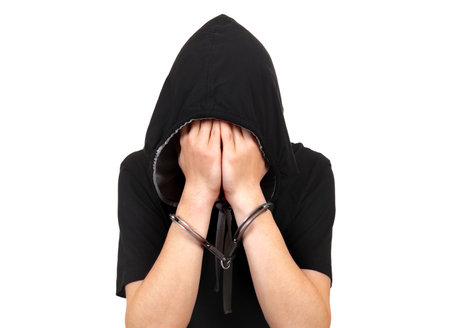 Sad Young Man in Handcuffs Isolated on the White Backgroundの写真素材