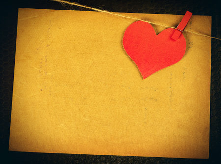 Red Heart Shape on the Rope on the Old Paper Background closeupの写真素材