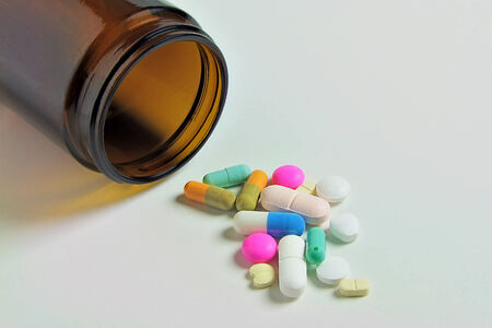 Medicine Bottle with colorful Pills and Capsules, close up, isolated on whiteの写真素材