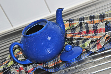 Blue Tea Pot with Water Drops on a Kitchen Sink, close upの写真素材