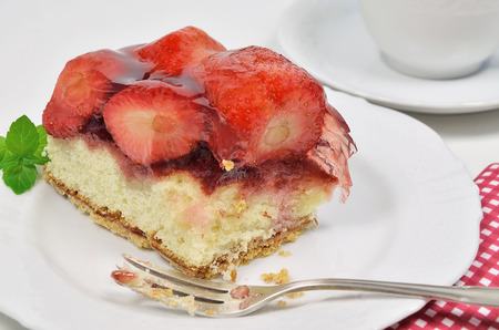 A Piece of Strawberry Pie, missing Bite, on white Plate with silver Fork, close upの写真素材