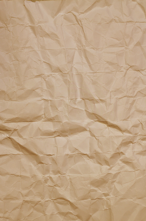 Close up of a creased, ocher paper texture, full frame, verticalの写真素材