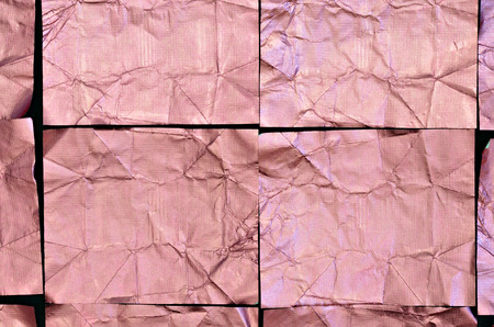 close up of creased pink aluminum foil squares on black background, full frame, flat lay, horizontalの写真素材