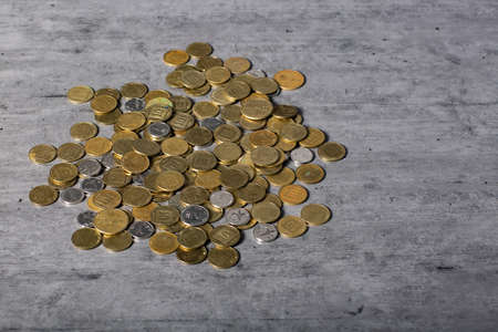 Coins of Israeli shekels on the table. Flat lay, top view. Copy space for any design. Scattered coins of 10, 50 agorot, Israeli ONE new Shekel coin. Close-up of Israeli Coins.の写真素材
