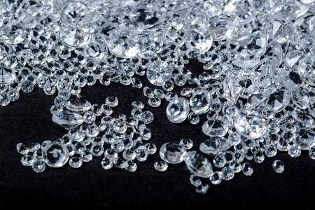 diamonds on black background. Blue and White brilliant gems, side view with copy space for your text. Studio shot, selective focus. Pile of Faux Diamonds. Plastic in granules. Scattering of crystalsの写真素材