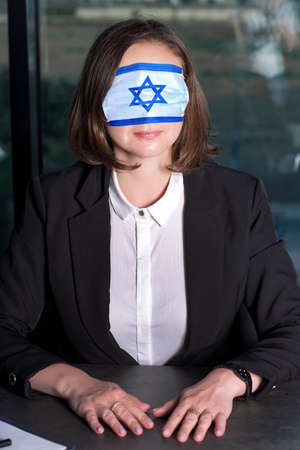 Woman in face medical mask with the image of the flag of Israel. Female wearing Medical Mask Cover...