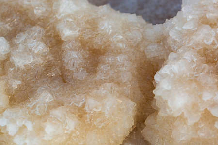 Big crystal of salt of Dead Sea, macro. The stones are covered with a crust of salt on the shores of the Dead-Sea, Ein Bokek beach, Israel. Extraction of salt. Salt on the seashore. crystallization.の写真素材