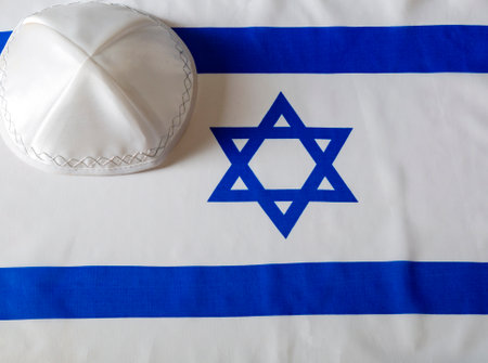 Star of david, yarmulke kippa on israeli flag. Kippah (religious hat) with the flag of Israel in the background. Still Life of Jewish symbols for Sukkot, shabbat, rosh hashanah and Yom kippur.の写真素材