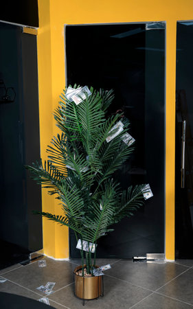 Decorate christmas decorative money tree in flower pot strewn with dollar banknotes. Dollar Christmas artificial palm tree. New year fir tree is decorated with 100 dollars cash. Palm firtree.の写真素材