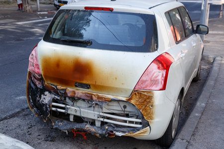 A burnt out car in the early morning mist. The morning after a traffic accident. Setting fire to cars, terrorist attack, mafia. Remains of a burned out car on roadside. rear view of burned out carの写真素材