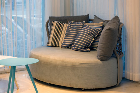 Stylish living room with sofa. Interior design in gray colors. Earth tone style sofa and pillows...