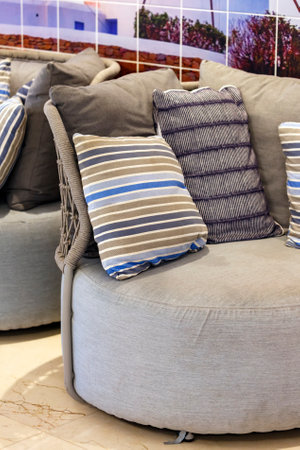 Pillows on sofa in modern living room. A modern farmhouse home decor scene with couch end throw pillow. Elegant sitting room interior with striped pattern pillows on settee in gray tone color. Decorの写真素材
