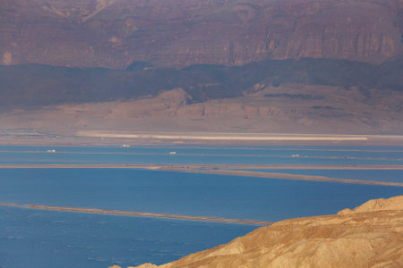 Shore of Dead sea in Ein Bokek, Israel, white salt crystals outside and at the bottom, turquoise clear water. dead sea coastline. Salt crystals at sunset. Texture of dead sea. Salty sea shore, Israelの写真素材