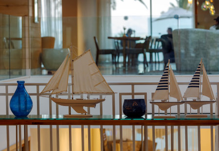 Table decoration of glass luxurious blue vase with beautiful a yachts on table, blurred background. The decor of the table in a marine theme, with vases. Nautical concept image with sailboat yachtsの写真素材