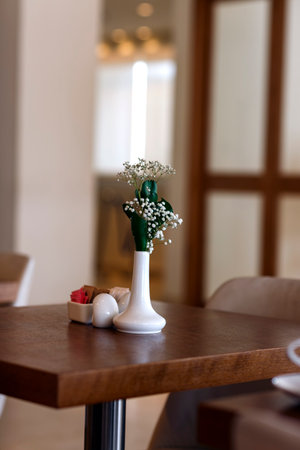 kitchen interior. small white gypsophila flowers in vase on wooden table. Few twigs with small white flowers of Gypsophila (Baby's-breath) against light background. Space for text, selective focus.の写真素材