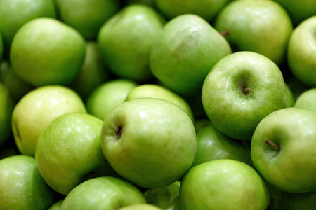 Stack of fresh green apples background, close up. Backgrounds of ripe juicy apples fruits from market. Picked apple, natural freshness, vegetarian food. Jewish New Year, Rosh Hashanah. Selective focusの写真素材