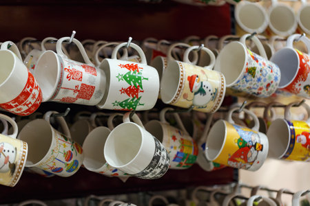 Happy new year day coffee cups in the store. Concept of shopping for home. New Year's Eve. Cozy mugs with English text Merry Christmas in tableware department at mall. Set of multicolored glass cupsの写真素材