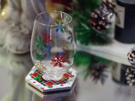 Transparent glass with Christmas snowflake glitter patterns on them. Elegant New Year's family dinner table setting and festive decor. Table setting for a Christmas Eve dinner with Clear empty glassの写真素材