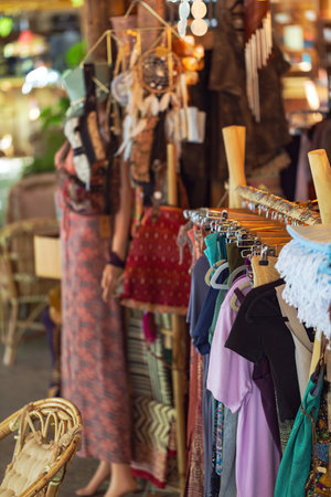 Clothes at an outdoor market stall filled with an array of garments and handmade goods. The focus is on the clothing rack in the foreground in a traditional bazaar setting. Second hand marketの写真素材