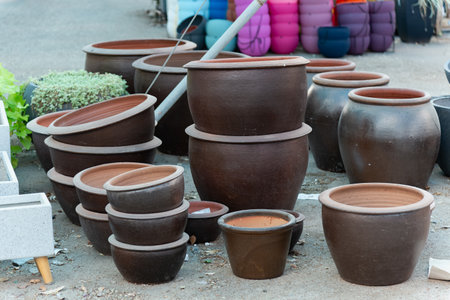 Stacked ceramic and clay pots in a pottery shop showcase a variety of terracotta planters and decorative garden containers. These eco-friendly pots add rustic charm to any garden or backyard decor.の写真素材