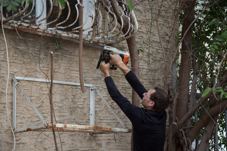Man with the chainsaw. Dangerous job. Powerful chainsaw. Lumberjack hold chainsaw. Gardener...