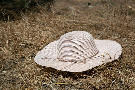 woman hat on a haystack. Beige Women's beach cap. colorful Wicker farmer hat in the background of hay. yellow hat Summer travel concept, vacation at sea, farm. Banner. Flat lay, top view, copy space.の写真素材