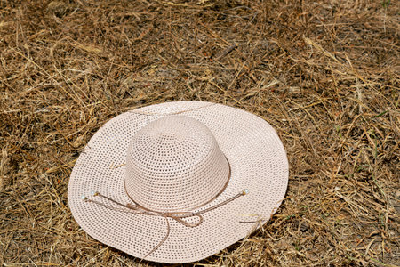 woman hat on a haystack. Beige Women's beach cap. colorful Wicker farmer hat in the background of...