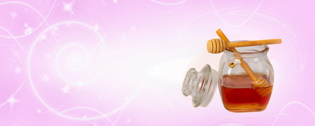 Honey jar with dipper and honeycombs on pink backgroundの写真素材