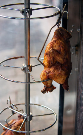 roasted chicken on a spit in a restaurant, close-upの写真素材