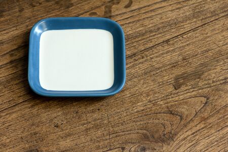 empty square white and blue color dish on wood tableの写真素材