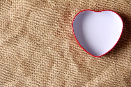 white in iron box shape heart form on crease burlap cloth . Lots of copy spaceの写真素材