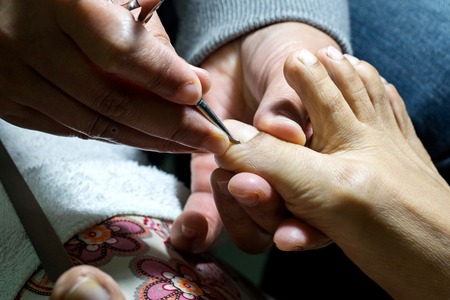 professional doing manicure pedicure work on hand and footの写真素材