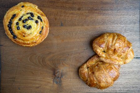 croissant danish bakery on teak wood table lighting and gray backgroundの写真素材