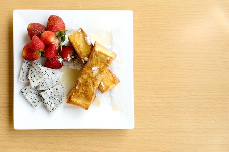 strawberry fantasy honey toast on square white dish wood tableの写真素材
