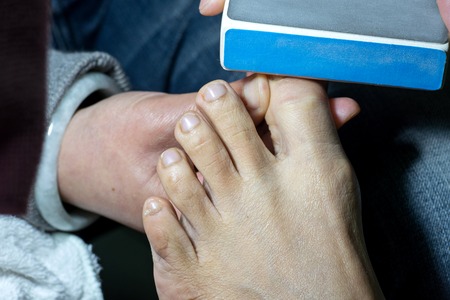 professional doing manicure pedicure work on hand and footの写真素材