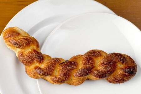 top view of spiral bread gold color bun on white plateの写真素材