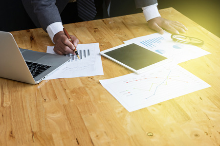 business man stand at the head of the table in boardroom use computer and tablet black backgroundの写真素材