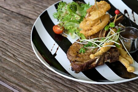 pork steak serve on back and white dish plate old wood table