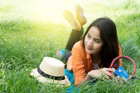 beautiful asian woman lay on grass for relax herselfの写真素材