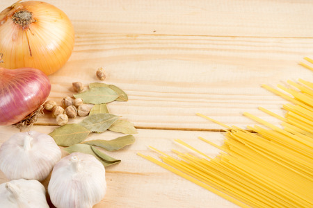 wood background onion spaghetti vegetable raw cookingの写真素材