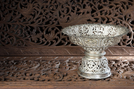 silver tray with pedestal Thai style on teak wood craftの写真素材