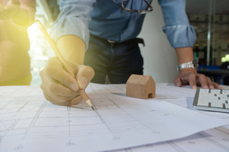 Architect or engineer working on blueprint and architecture model in office room, Construction concept. Engineering tools.Vintage tone の写真素材